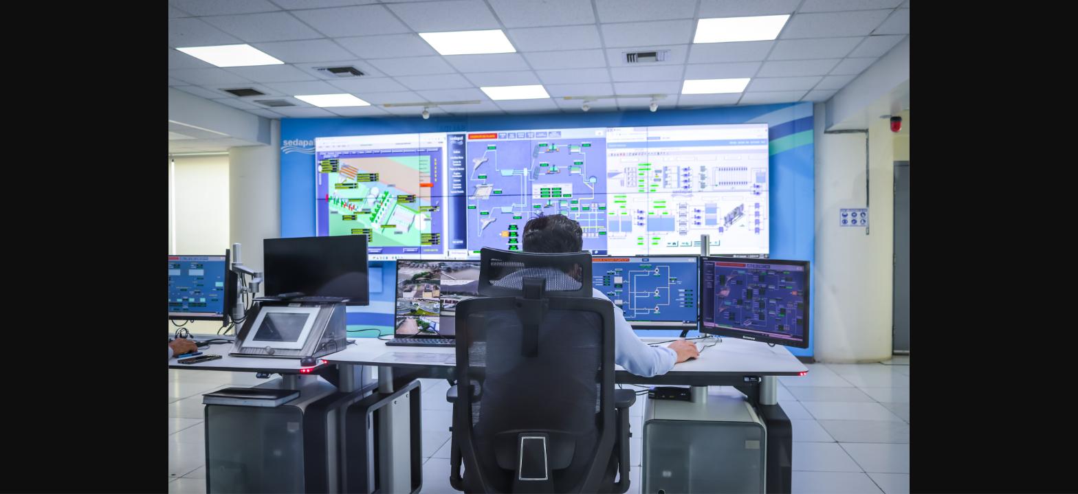Operator monitoring building systems on a large control room video wall