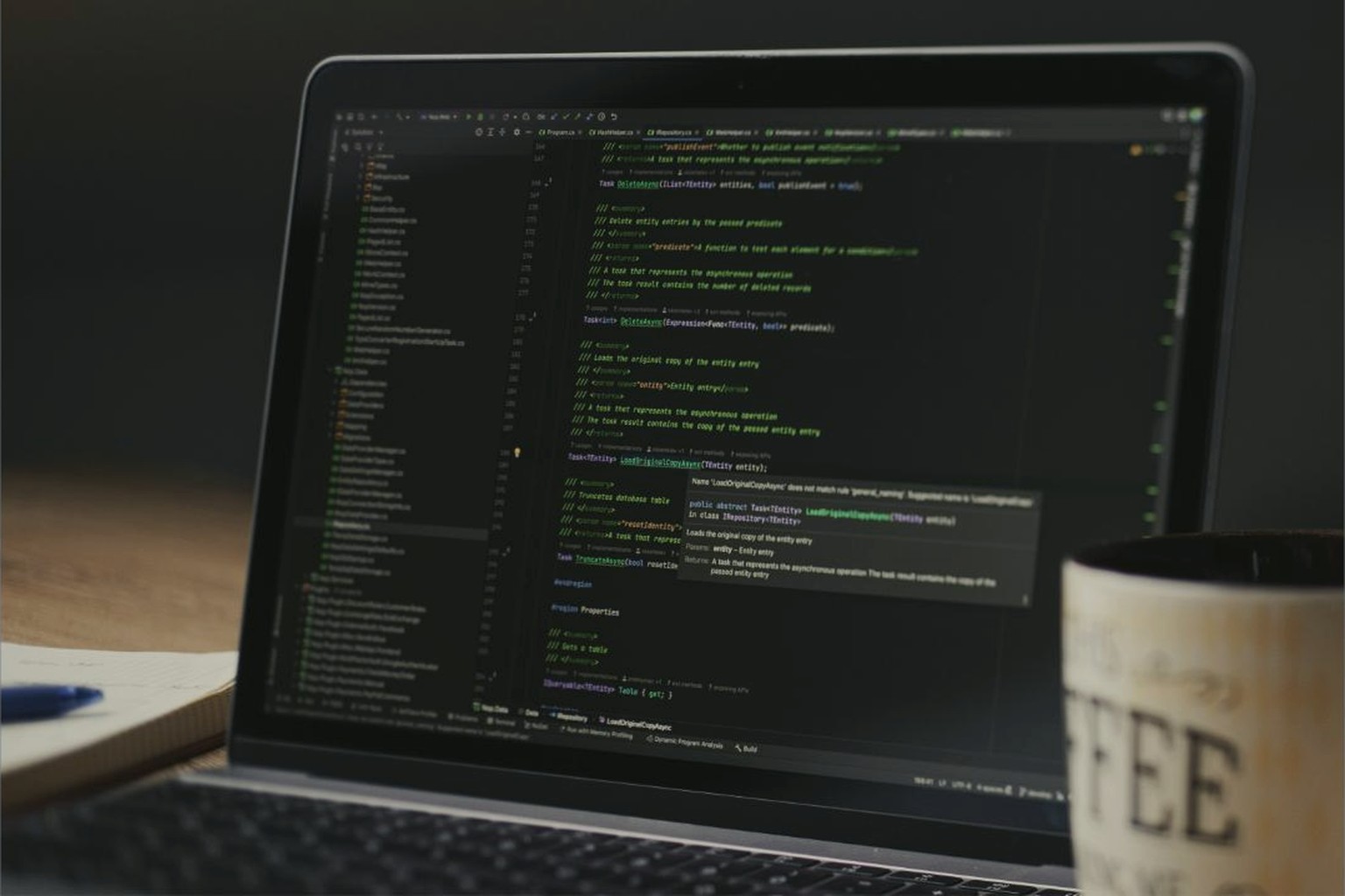Laptop with code next to a coffee mug