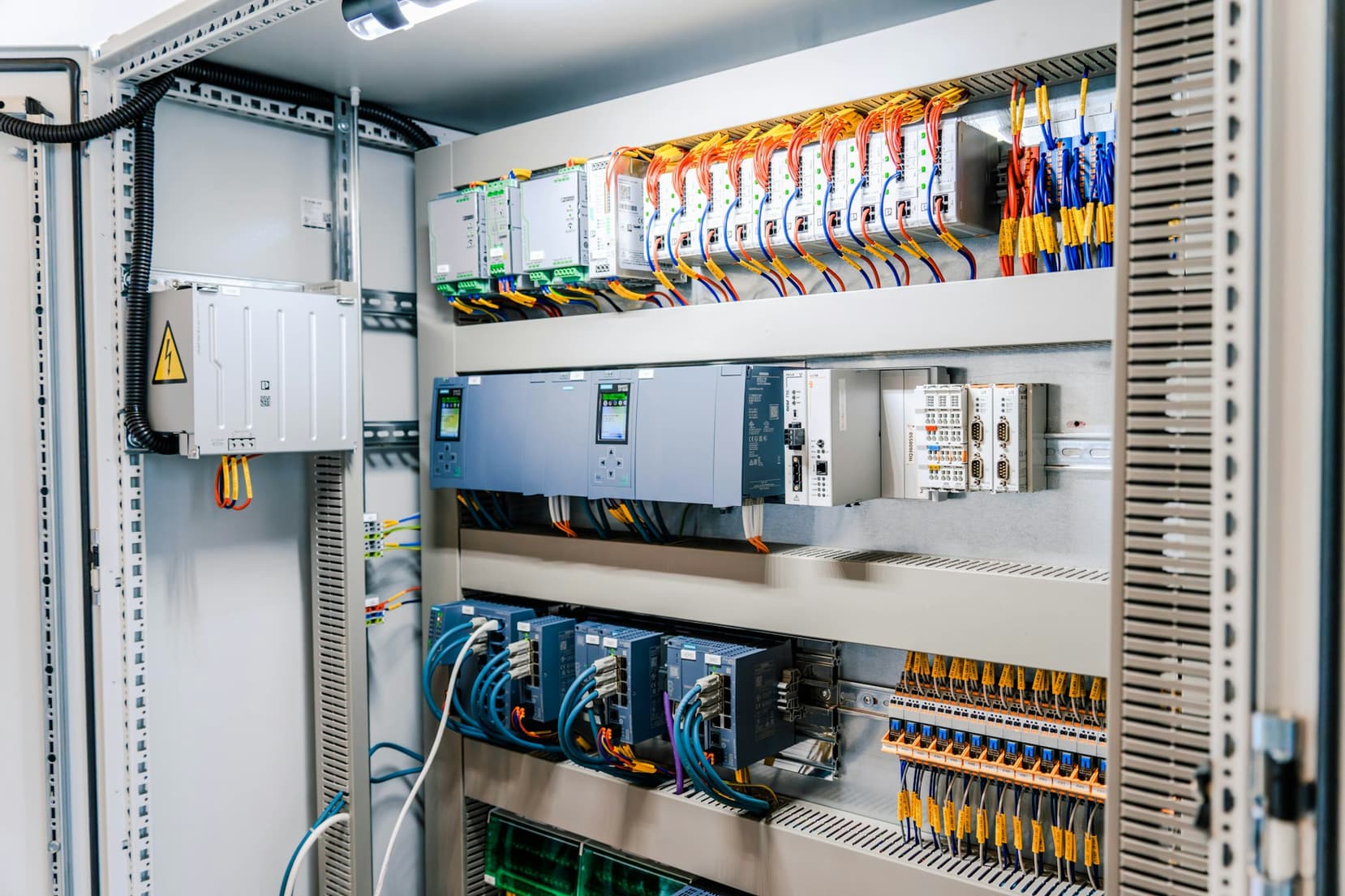 Open building automation control cabinet with controllers, wiring and labelled terminals